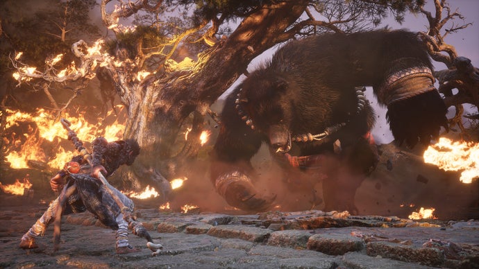 A monkey warrior fights a large flaming bear in Black Myth: Wukong