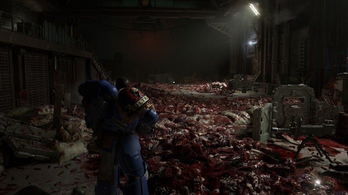 A screenshot of Warhammer 40,000: Space Marine 2, showing Titus standing in front of the grisly remnants of a large battle.