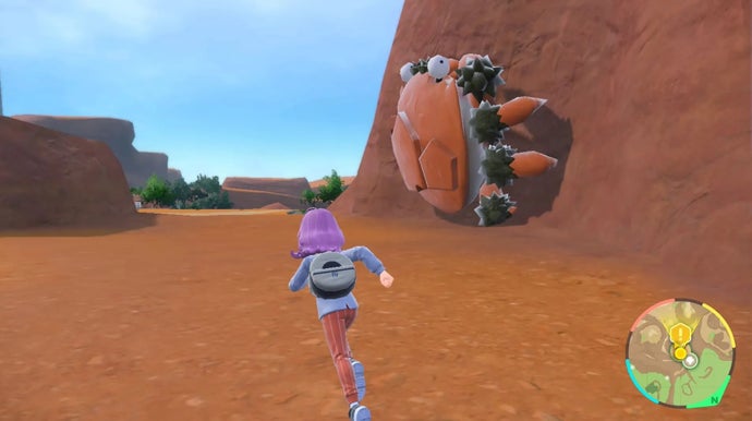 Pokémon Scarlet and Violet screenshot showing very limited mud textures with a giant Pokémon on the wall